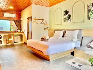 a bedroom with a large bed and a couch at สต็อกโฮม เขาใหญ่ (StockHome Khao Yai) in Khanong Phra