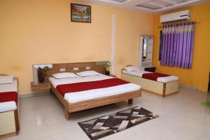 2 Betten in einem Zimmer mit gelben Wänden in der Unterkunft Hotel Padmapani Park Fardapur in Phardāpur
