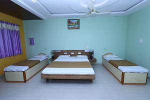 ein Krankenhauszimmer mit 3 Betten und einer Decke in der Unterkunft Hotel Padmapani Park Fardapur in Phardāpur