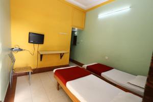 Zimmer mit 2 Betten und einem TV an der Wand in der Unterkunft Hotel Padmapani Park Fardapur in Phardāpur