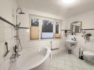 a bathroom with a tub and a toilet and a sink at BohnApartments Juwel am See, mitten in der Natur - gratis Parkplatz - Kamin - WLAN - Nähe Erfurt in Kranichfeld