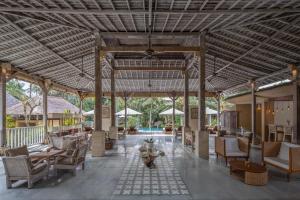 a lobby of a resort with chairs and tables at Wapa di Ume Ubud in Ubud