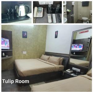 a hotel room with a bed and a television at Hotel Sapthagiri Nest in Coimbatore
