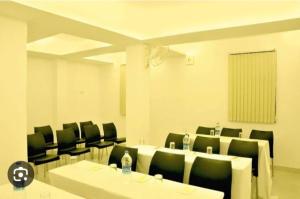 a conference room with a long table and chairs at Hotel Sapthagiri Nest in Coimbatore