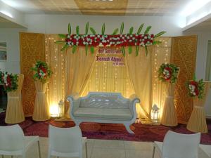 a stage with a bed and a curtain at Hotel Sapthagiri Nest in Coimbatore