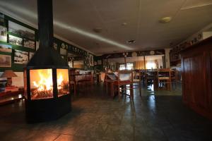 a fireplace in the middle of a room with a restaurant at Kaapsche Hoop Gastehuis in Kaapsehoop