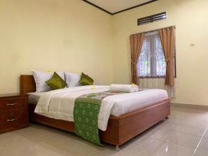 a bedroom with a large bed and a window at Green Orry Inn in Tetebatu