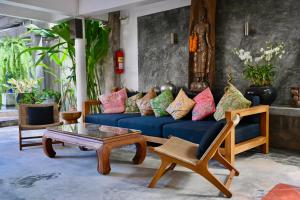 a living room with a blue couch and a coffee table at PapaCrab Boutique Guesthouse in Kamala Beach