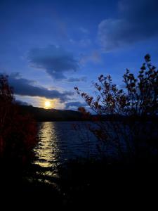 a sunset over a lake with the sun in the sky at Loch Morar Private Suite in Mallaig