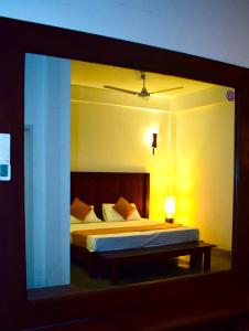 Habitación con vistas a un dormitorio con cama y lámpara. en Airport Heritage Hotel en Katunayaka