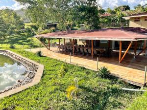 a house with a deck next to a pond at Zebi Ecolodge in Hoima