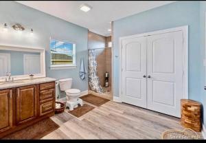 e bagno con servizi igienici, lavandino e doccia. di OceanFront home near HollyBeach a Cameron