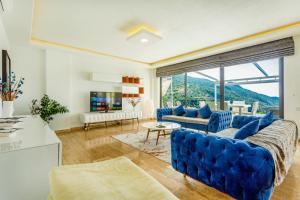 ein Wohnzimmer mit blauen Möbeln und einem großen Fenster in der Unterkunft infinity paradise in İslâmlar