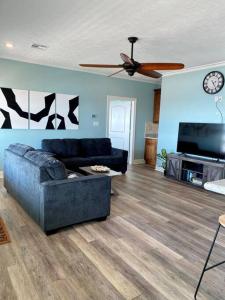 a living room with a couch and a ceiling fan at OceanFront home near HollyBeach in Cameron