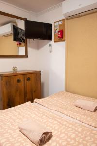 ジュラにあるErika Mini Apartmanのベッド2台、薄型テレビが備わる客室です。