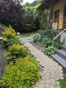 a garden with a stone walkway next to a house at Domek przy lesie 2 in Gdańsk