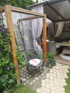- une terrasse couverte avec une chaise roulante dans le jardin dans l'établissement Domek przy lesie 2, à Gdańsk