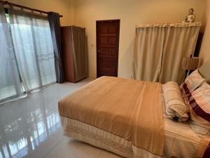 a bedroom with a bed and a large window at Roland Villa in Koh Samui 