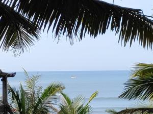 a view of the ocean from a palm tree at Redkar Rooms Gokarna Beach front AC And Non AC Rooms in Gokarn