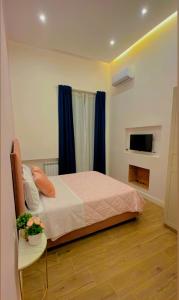 - une chambre avec un lit, une table et une télévision dans l'établissement Home Piccini, à Naples