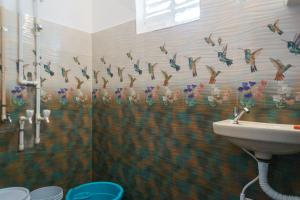 bagno con lavandino e uccelli sul muro di Sweet Spot a Pondicherry