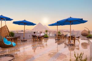 a group of people sitting at tables with umbrellas at Blue Pyramids Eyes Hotel in Cairo