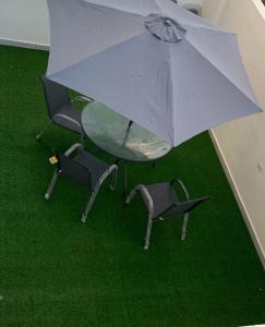 una vista sul soffitto di un tavolo in vetro e di sedie con ombrellone di رويال جروب اربد Royal Group Hotel a Irbid