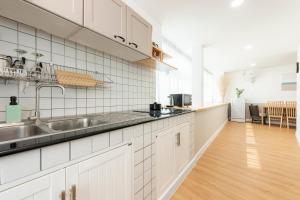a kitchen with white cabinets and a stainless steel sink at Lee's Mark Residence in Bangna