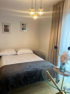 a bedroom with a bed and a glass table at Nowoczesny apartament w centrum Starego Miasta, strzeżony parking in Zamość