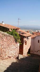 um grupo de edifícios com uma parede de pedra em Casa Castillo em Vilafamés