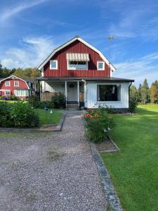 a red and white house with a yard at Villa på landet i Kulltorp in Kulltorp