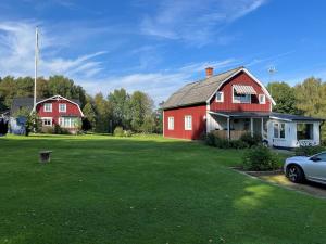 a red house with a car parked in a yard at Villa på landet i Kulltorp in Kulltorp