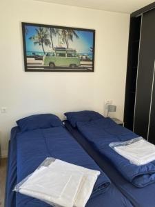 a bedroom with two beds and a picture of a car at Enkhuizer Strand Chalet Möwennest Zweite Reihe Haus Nr 261 in Enkhuizen