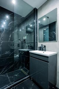 een zwarte badkamer met een wastafel en een douche bij Luxury Downtown Apartment Α1 in Thessaloniki