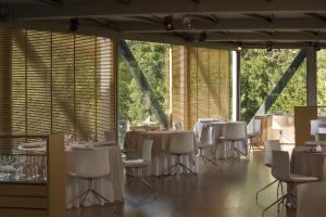 a dining room with white tables and white chairs at Hotel Món Sant Benet in Sant Fruitos de Bages