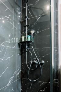y baño con ducha y pared de mármol negro. en Luxury Downtown Apartment Α1, en Tesalónica