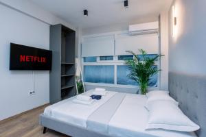 1 dormitorio con cama blanca y ventana en Luxury Downtown Apartment Α1, en Tesalónica