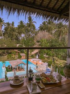 a table with food and a view of a pool at El Nido Moringa Resort in El Nido