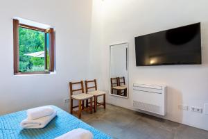 een slaapkamer met een bed en een flatscreen-tv bij Can Xumeu Ferrer in La Mola