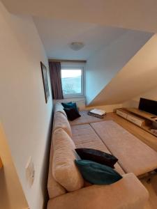ein Wohnzimmer mit einem Sofa und einem Fenster in der Unterkunft Apartment Ledermoos in Mauterndorf