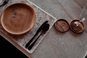 a wooden cutting board next to a spoon and a knife at Poco Poco villas by Aayan in Jimbaran