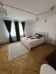 a bedroom with a bed and a wooden floor at central place in Braşov