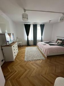 a bedroom with a bed and a dresser and a window at central place in Braşov
