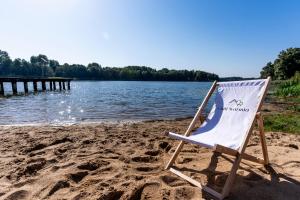 una silla sentada en una playa junto al agua en Chill Warmia en Dywity