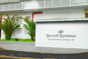 a white building with a sign on the side of it at SEA BREEZE HOLIDAYS HOME in Colombo