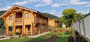 una casa de madera con un patio delante de ella en Troya Chalets, en Baba Stana