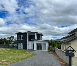 una casa en blanco y negro con entrada en Lakeside cozy studio en Taupo