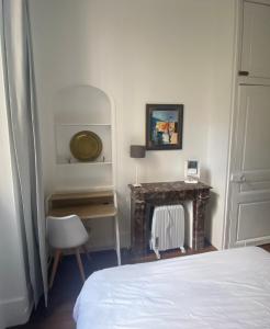 a bedroom with a bed and a chair and a fireplace at Kak's apartments Paris in Paris