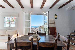 salon ze stołem i dużym oknem w obiekcie La Cueva w mieście Mijas
