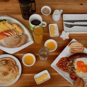 a wooden table topped with plates of breakfast foods at El Nido Moringa Resort in El Nido